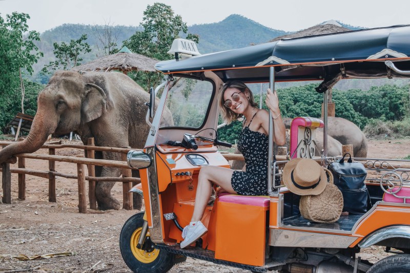 Woman on tuk tuk near elephant in Thailand