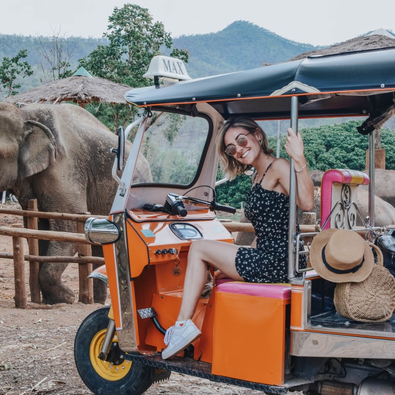 Woman on tuk tuk near elephant in Thailand
