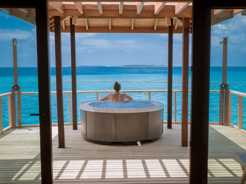 Woman in spa overlooking blue ocean