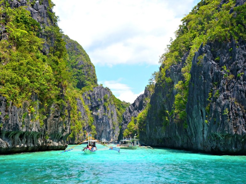 Green covered cliffs coming out of the turquoise sea