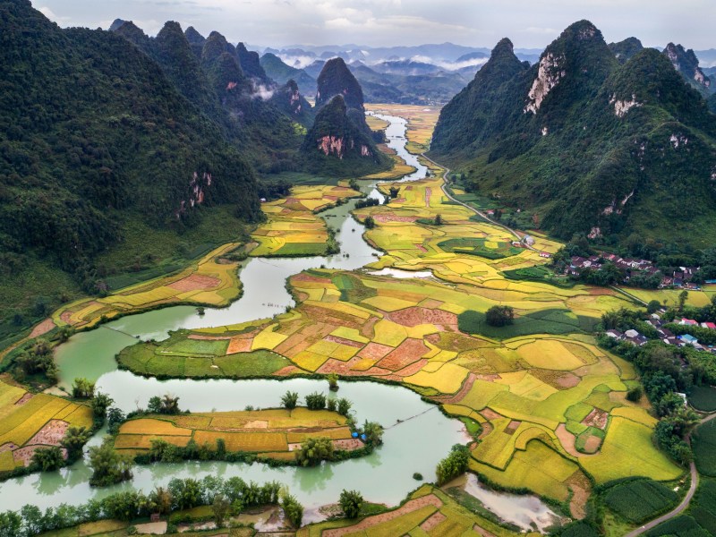 River running through rice paddies and green mountains