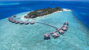 Villas over blue water on small island in Maldives