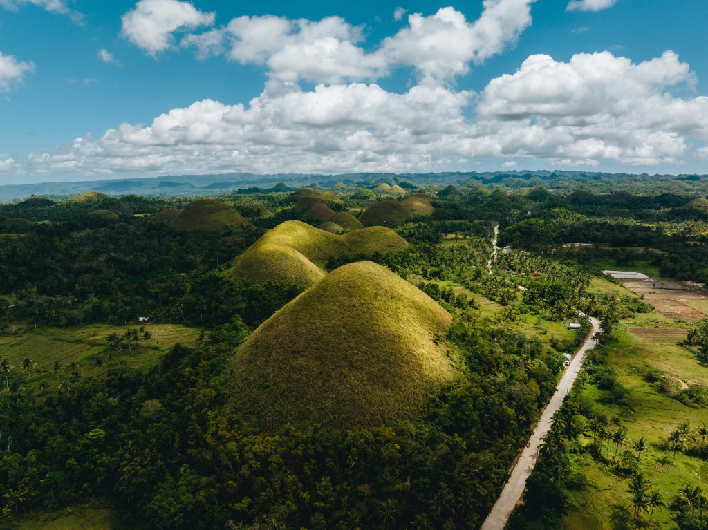arial view of green mountains with blue skies